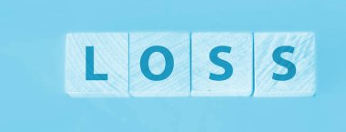 Gök mavisi arka planda kayıp sözcüğü olan tahta küpleri. Mali kayıp meşguliyet kavramı