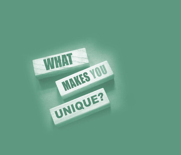 Что делает Yiu уникальным - фраза на блоках Wooden. Концепция успеха бизнеса или каруселей.