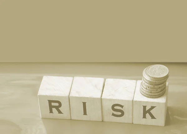 나무 입방체와 동전에 써 있는 RISK 단어입니다. 재정적 위험 평가, 위험 보상 및 포트폴리오 위험 관리 비즈니스 개념. — 스톡 사진