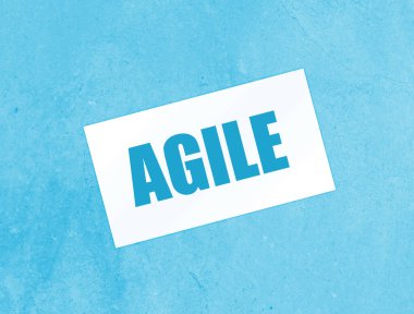 Kağıt kartvizitte AGILE yazılı, ahşap arka planda yakın plan. İş Konsepti