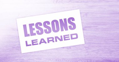 Ahşap arka planda öğrenilen mesajlarla dolu boş bir kart. İş konsepti.