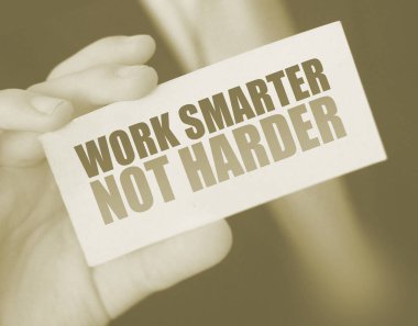 İş adamı üzerinde motivasyon mesajı yazan bir kart tutuyor. Daha akıllı ol, daha akıllı değil..