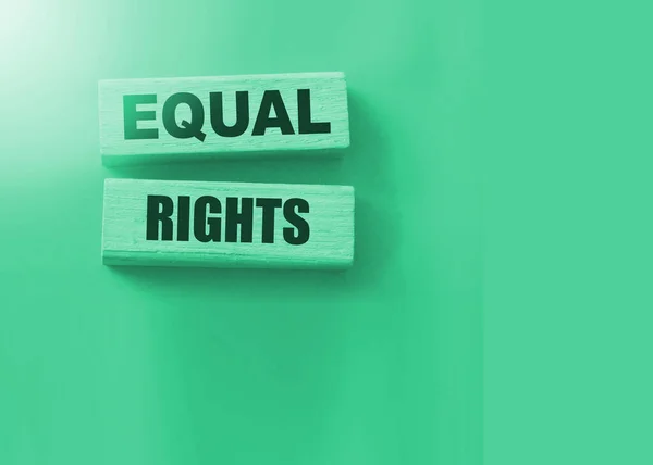 Equal Rights, words on wooden blocks on green background. Equality social concept.
