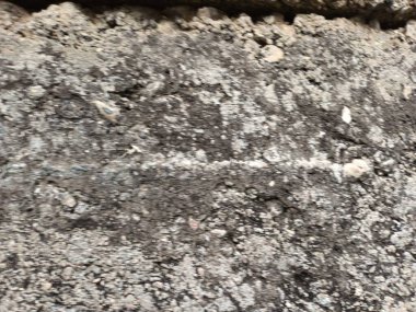 Çatlakları ve çizikleri olan taş bir duvarın dokusu arka plan olarak kullanılabilir.