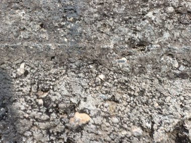 Çatlakları ve çizikleri olan taş bir duvarın dokusu arka plan olarak kullanılabilir.