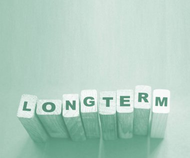 Cyan açık mavi arka planda tahta küplerle ilgili uzun vadeli bir kelime. Güvenilir iş uzun vadeli ilişki kavramı. 