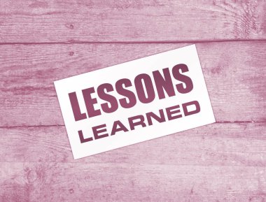 Ahşap arka planda öğrenilen mesajlarla dolu boş bir kart. İş konsepti.  