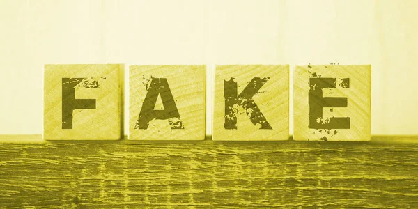 木製のブロックに偽の単語の文字は 暗いオークのテーブルの上に 真とビジネスとニュースの概念に嘘をつく — ストック写真