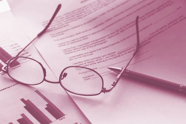 Business legal document concept : Pen and glasses on a agreement form.
