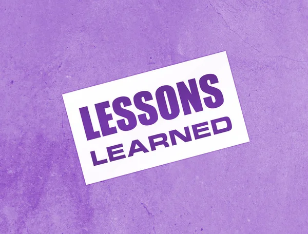 Ahşap arka planda öğrenilen mesajlarla dolu boş bir kart. İş konsepti.