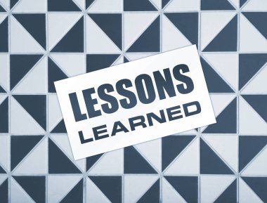 Ahşap arka planda öğrenilen mesajlarla dolu boş bir kart. İş konsepti.