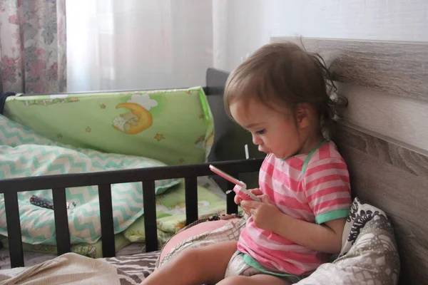 おもちゃの携帯電話で遊んでいる家でかわいい幸せな子供の肖像画の景色 — ストック写真