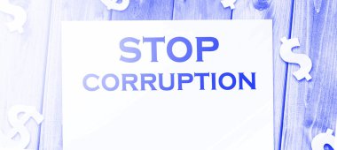 Sayfadaki Yolsuzluk Sözcükleri 'ni ve ahşap masadaki kağıt para işaretlerini durdurun. Yolsuzlukla mücadele konsepti.