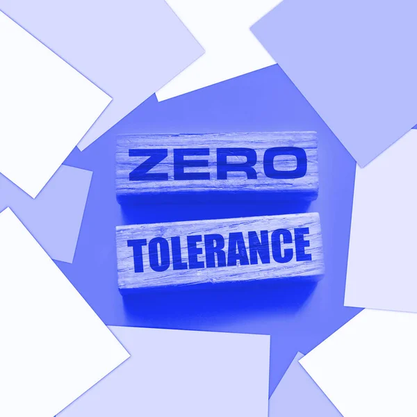 Zero tolerance - words from wooden blocks with letters, severely punishing all unacceptable behaviour, zero tolerance concept, yellow background.