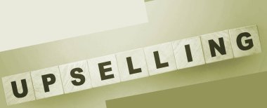 Yeşil eğimli arka planda tahta küplerle ilgili kelime UPSELING. İş konsepti.