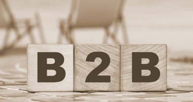 İş 'ten İş' e. Tahta küplere B2B harfleri. Güneşli sahil ve okyanus arka planı. Çevrimiçi ticaret kavramı.