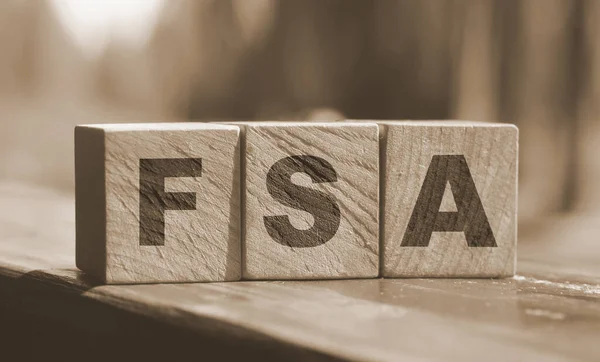 Flexible spending account FSA written on a wooden cubes. Financial concept.