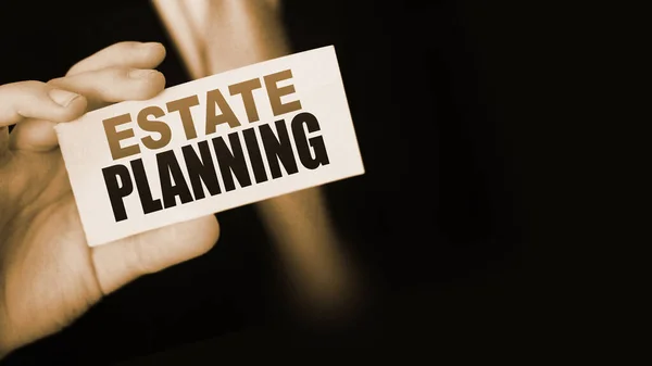 Estate Planning words on card a businessman shows. Real estate business concept.