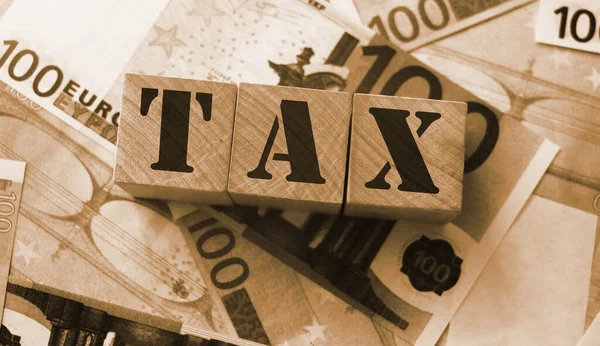 Tax 字填上100欧元钞票的木块 税务财务会计概念 — 图库照片