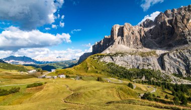 Gardena Geçidi ve Sass dla Luesa dolomite kulesi, Trentino Alto Adige, İtalya 'ya giden kadın yürüyüşçünün hava görüntüsü. Alp çayırları ve Passo Gardenya.