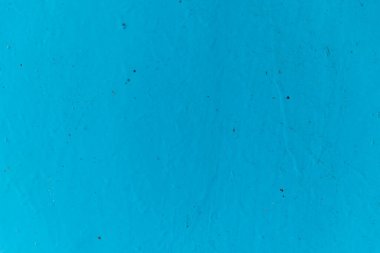 Duvarda mavi boya. Düz olmayan pürüzlü yüzey. Soyut arkaplan.