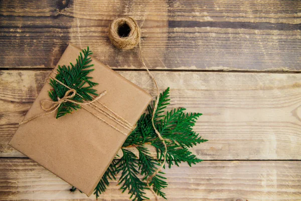Tahta bir arka planda Kraft kağıdı ve doğal sicimle dolu kutular. Teslimat servisi. Çevre dostu malzeme. El yapımı sanat eseri. Noel ve Yeni Yıl kavramı.