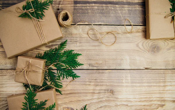 Tahta bir arka planda Kraft kağıdı ve doğal sicimle dolu kutular. Teslimat servisi. Çevre dostu malzeme. El yapımı sanat eseri. Noel ve Yeni Yıl kavramı.