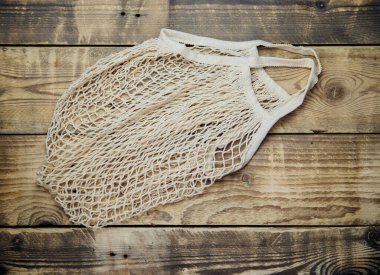 Sıfır atık kavramı, yeniden kullanılabilir ağ torbaları. Ahşap arka planda doğal pamuk kumaştan yapılmış. Sürdürülebilir bir yaşam tarzı. Üst görünüm.