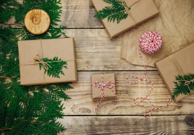 Kraft kağıdına doldurulmuş kutular ve ahşap bir arka planda yeşil dallar. Satılık. Çevre dostu materyal. Noel ve Yeni Yıl..