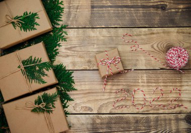 Kraft kağıdına doldurulmuş kutular ve ahşap bir arka planda yeşil dallar. Satılık. Çevre dostu materyal. Noel ve Yeni Yıl..