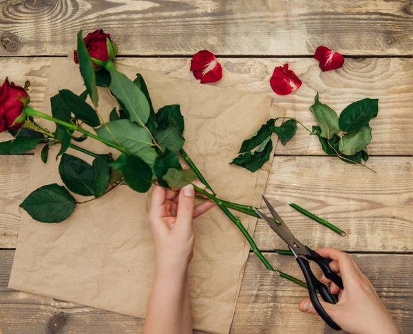 Çiçekçi çiçeklerden bir düzenleme yapar, kadınların elleri makasla gövdeyi keser. Bitkileri tazeler. Şenlik havası.