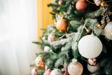 Yeni yıl için oyuncaklarla süslenmiş bir Noel ağacının dalları. Noel topları ve çelenkler. Noel arkaplanı. Şenlikli atmosfer.