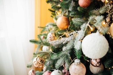 Yeni yıl için oyuncaklarla süslenmiş bir Noel ağacının dalları. Noel topları ve çelenkler. Noel arkaplanı. Şenlikli atmosfer.