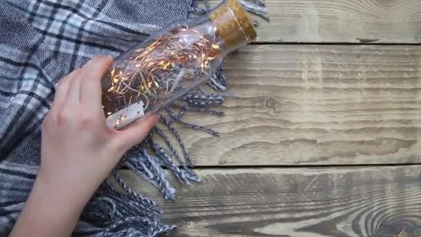 Women Hands Hold Glass Bottle Garland Christmas Lights Warm Grey — Stockvideo