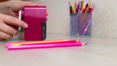 Bir kadının eli masada mekanik bir kalem açacağı tutuyor. Okula dönüyorum. Öğrenim için okul kırtasiyesinin hazırlanması.