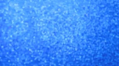 Parlak mavi arka plan malzemesi. Görüntü ve bokeh. Neşeli dokusu ışıkta parıldıyor..
