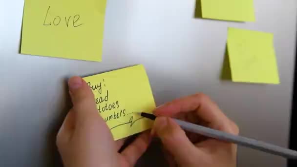 Een Gele Papieren Sticker Wordt Door Vrouwenhanden Aan Koelkast Bevestigd — Stockvideo