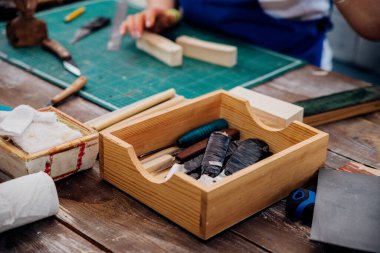 Masaüstünde bir kutu alet. Marangozluk atölyesi. Odun kesmek için bıçak ve aletler.