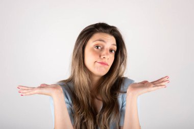 Sarışın kadın omuz silkiyor, ilgisiz tavırlar sergiliyor.