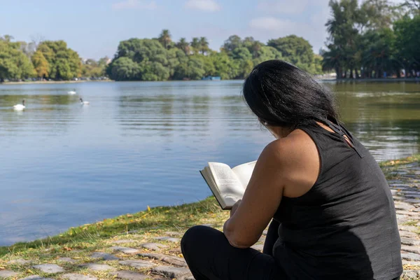 Mature Latin Woman Reading Book Sitting Lake — Stockfoto