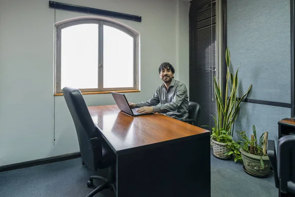 Businessman Sitting His Desk Working His Notebook Looking Camera Smiling — Stok fotoğraf