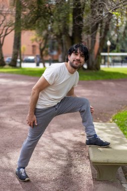 Yakışıklı, olgun, sakallı, atletik bir adamın portresi. 40 'larında, esneme egzersizi yapıyor, sabah antrenmanına hazırlanıyor.