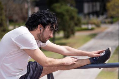 Yakışıklı, olgun, sakallı, atletik bir adamın portresi. 40 'larında, esneme egzersizi yapıyor, sabah antrenmanına hazırlanıyor.