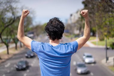 Başarılı bir adam koştuktan sonra kollarını kaldırdı. Kollarını kaldırıp spordan sonra başarıyı ve golleri kutlayan sporcu erkek sporcu. .