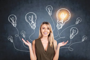 Elleri havada gülümseyen Avrupalı çekici genç kadın, yeni iş fikirleri ve başlangıç için kafa patlatıyor. Koyu mavi karatahtadaki ampullerin çizimi.