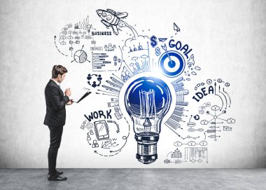 Resmi takım elbiseli iş adamı notlar alır ve elinde ampul, roket fırlatma, çark, iş, plan, duvarda takım çalışması olan bir robot resmin yanında durur. Hayal gücü kavramı ve yaratıcı fikirler için ilham.