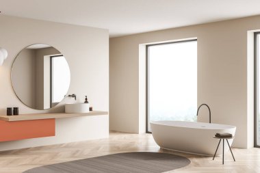 Küvetli bej banyo içi ve parke zemininde ayna, pencere kenarında halı, yan görüş. Modern mobilyaları ve kırsal manzarası olan minimalist bir oda.