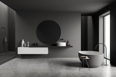 Küvetli banyo ve pencerenin yanındaki beton zeminde ayna olan lavabo. Köşesinde modern mobilya ve havlu merdiveni olan minimalist gri oda.