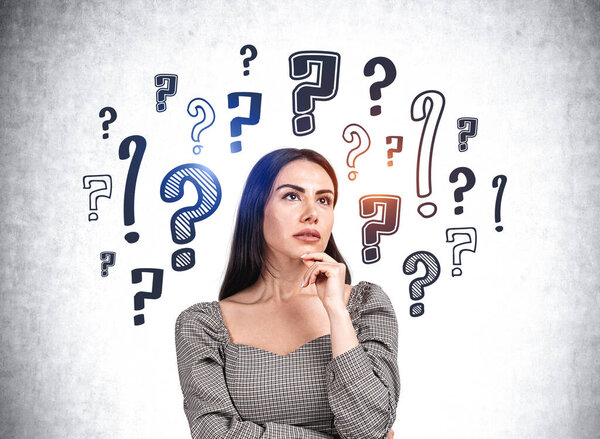 Портрет официантки в одежде, ищущей ответы, рука к подбородку думающей. Фон из каракулей вопросительных знаков нарисованных на серой стене. Концепция принятия решений и задачи