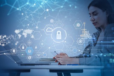 Gri elbiseli iş kadını akıllı telefondan mesaj yazıyor. Ofis işyerinin arka planında küre ve asma kilit olan dijital arayüzü var. Sanal arayüz ve veri koruması kavramı